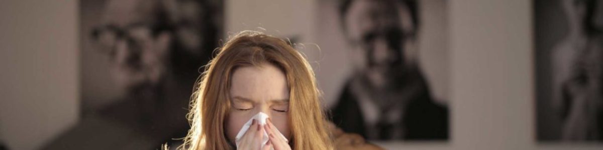 jente som nyser fordi hun har pollenallergi